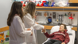 two female pharmacists talking to a young male patient