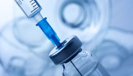 a syringe inserted into a medication vial